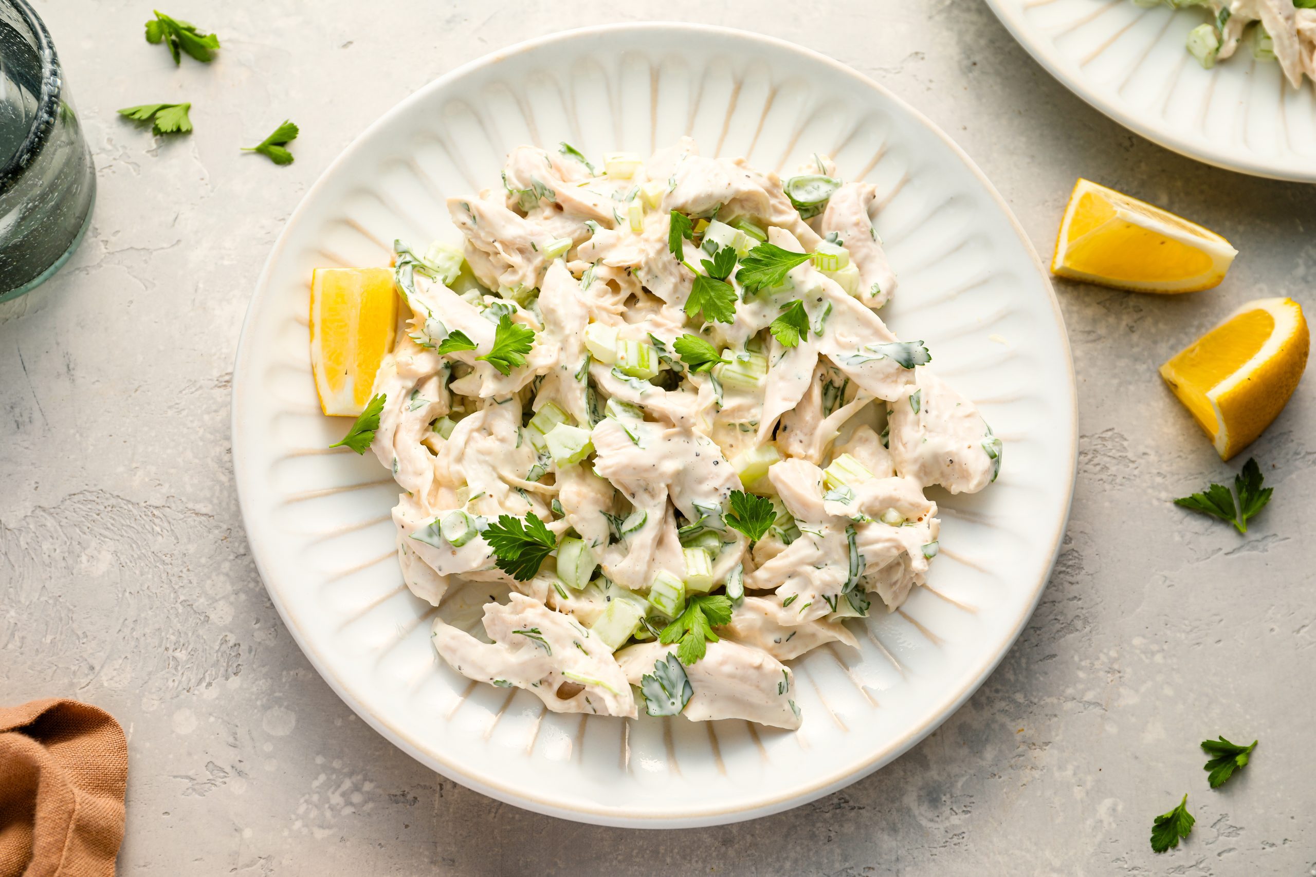 Chicken salad on plates with lemons.