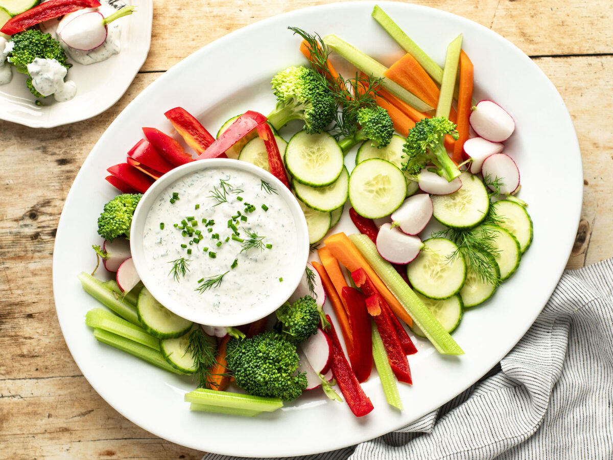 bowl of ranch dressing with platter of crudites.