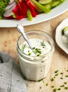 jar of ranch dressing with platter of crudites.