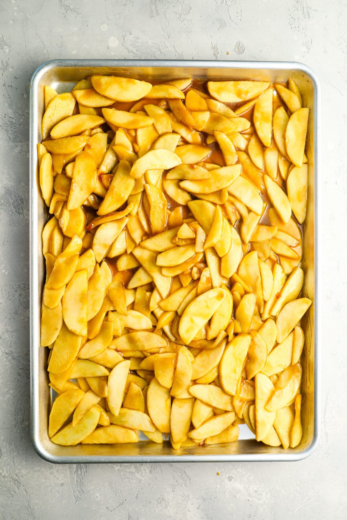 sliced cooked apples spread on baking sheet to cool