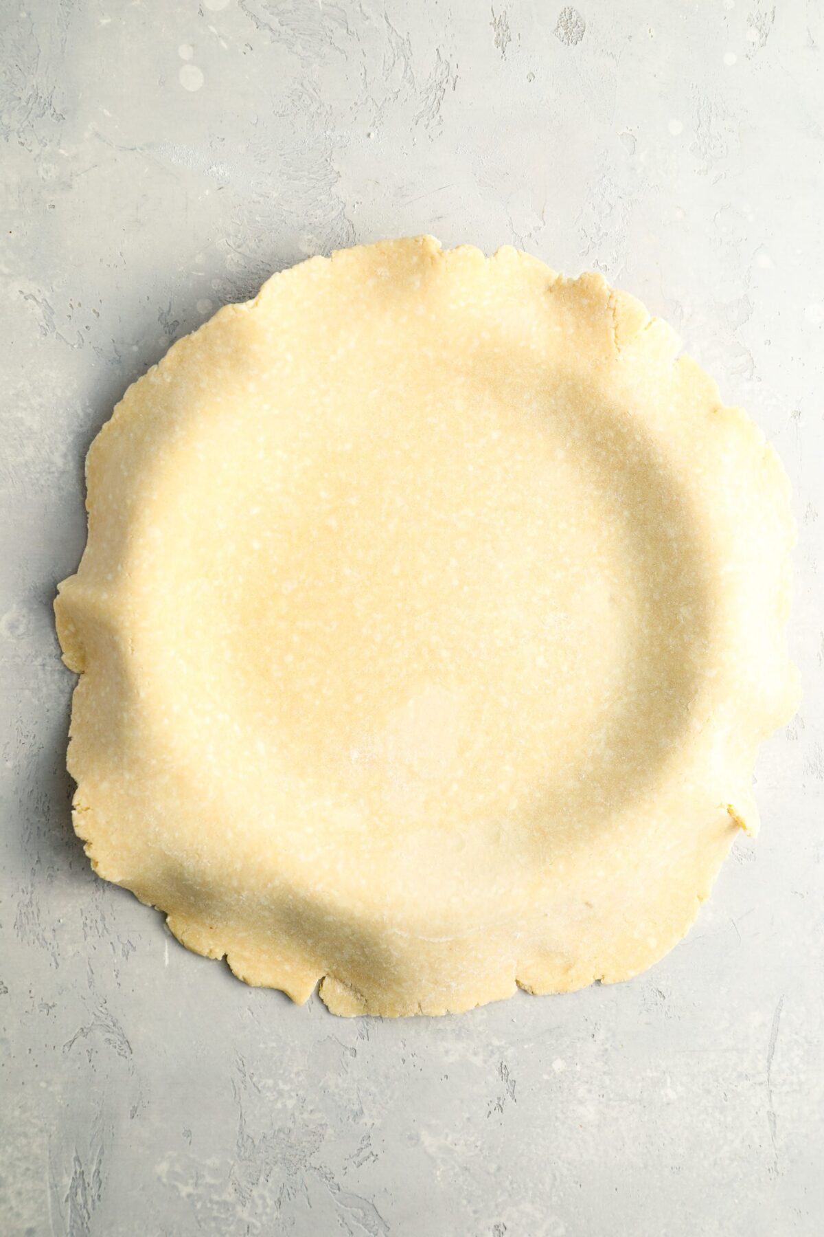 13-inch circle of dough placed on top of 9-inch pie pan
