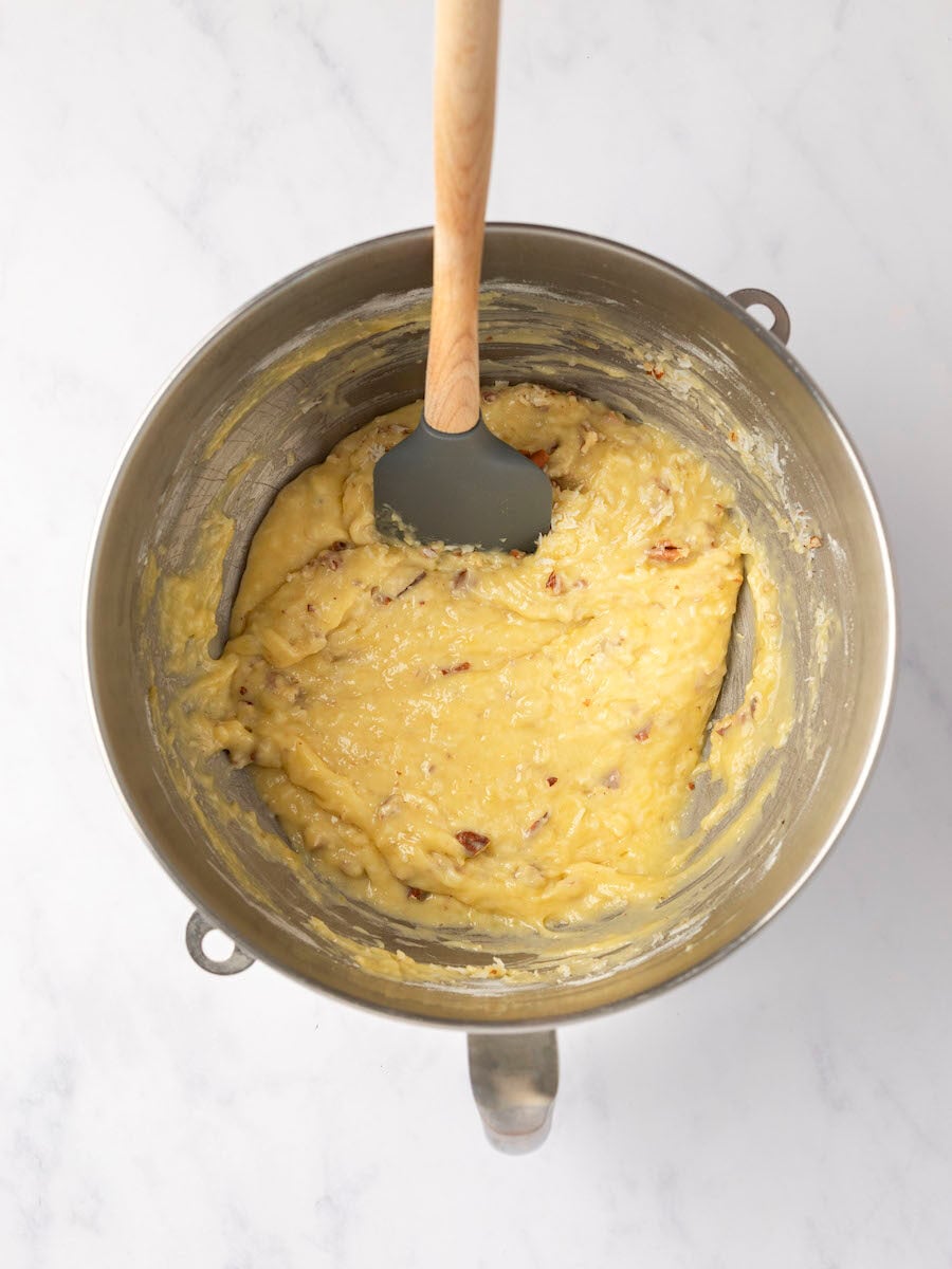 banana bread with coconut and pecans fully combined in metal mixing bowl
