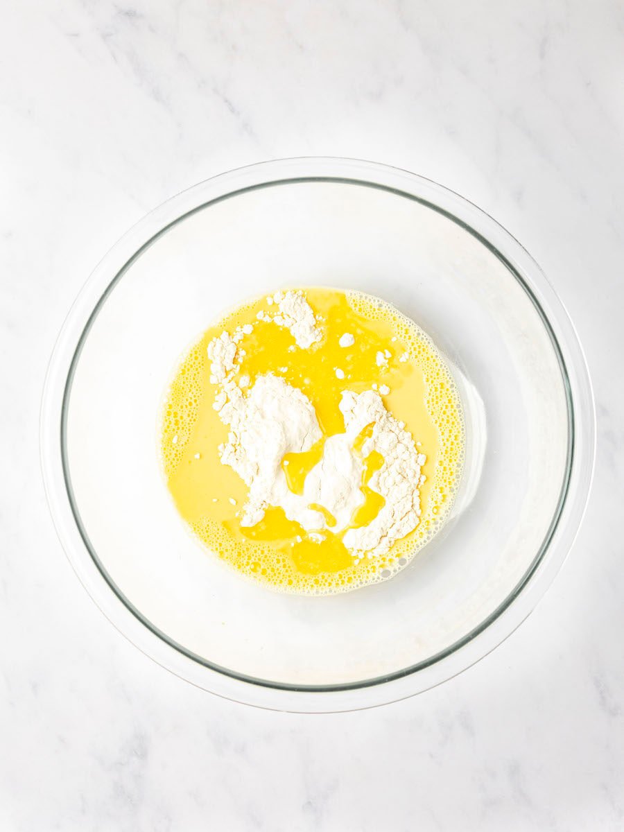 large bowl with flour added to egg yolks, milk, vanilla, and rum