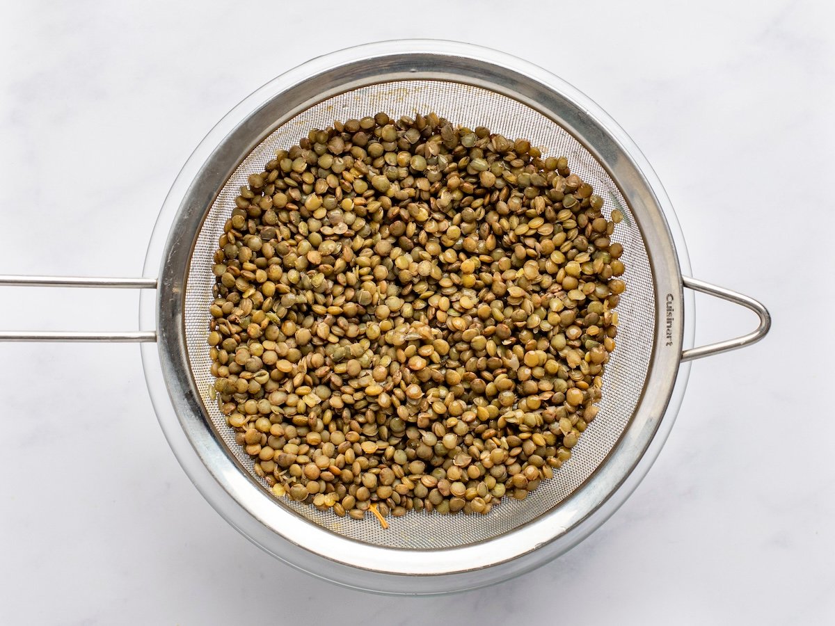 lentils in strainer over bowl.