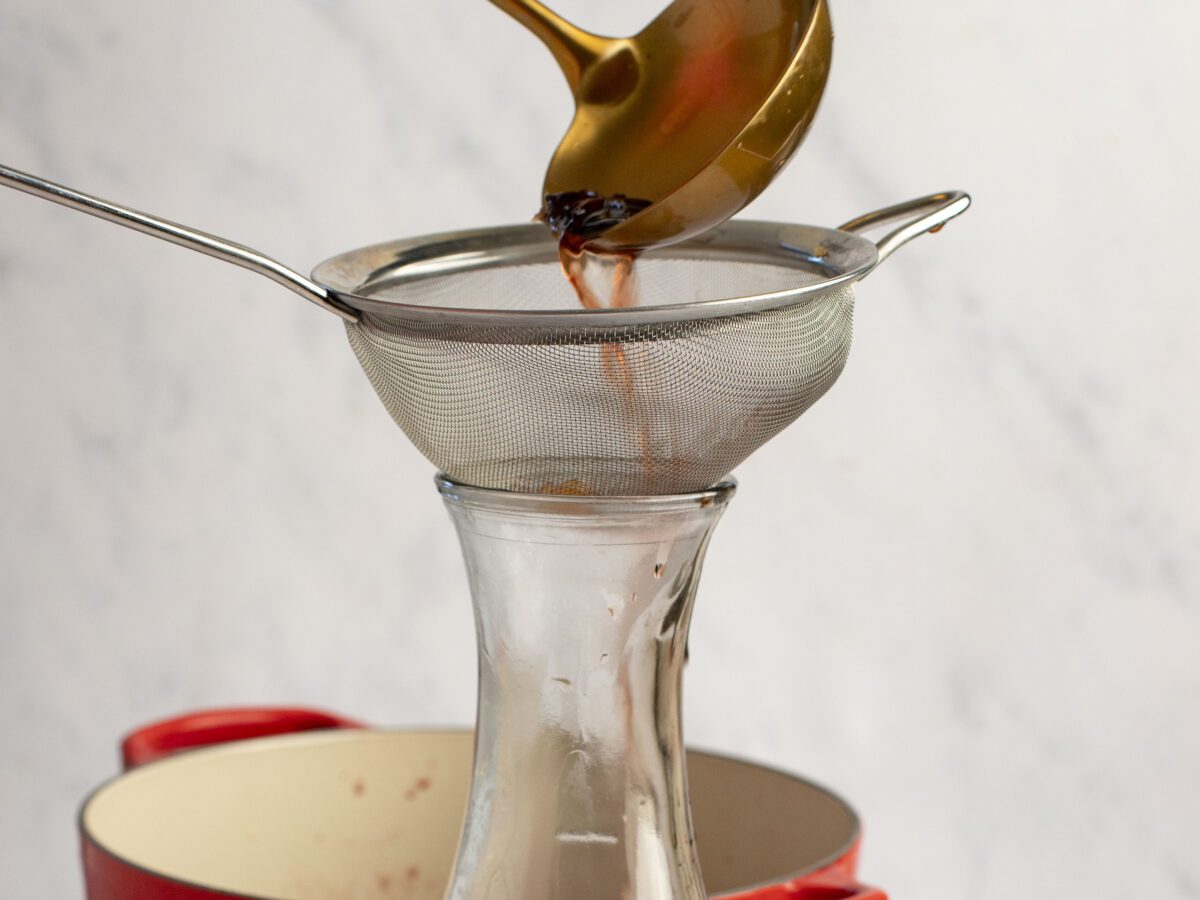 Straining the solids from the mulled wine
