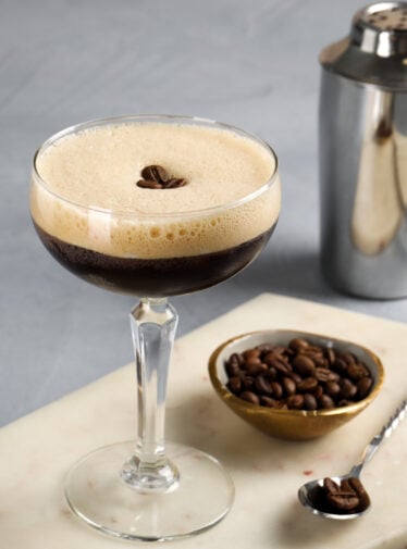 espresso martini garnished with coffee beans with cocktail shaker