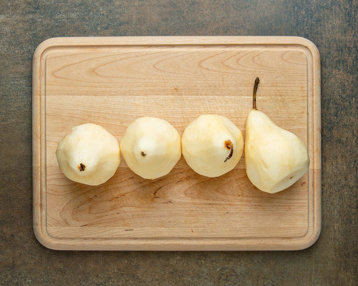 peeled pears on wood cutting board