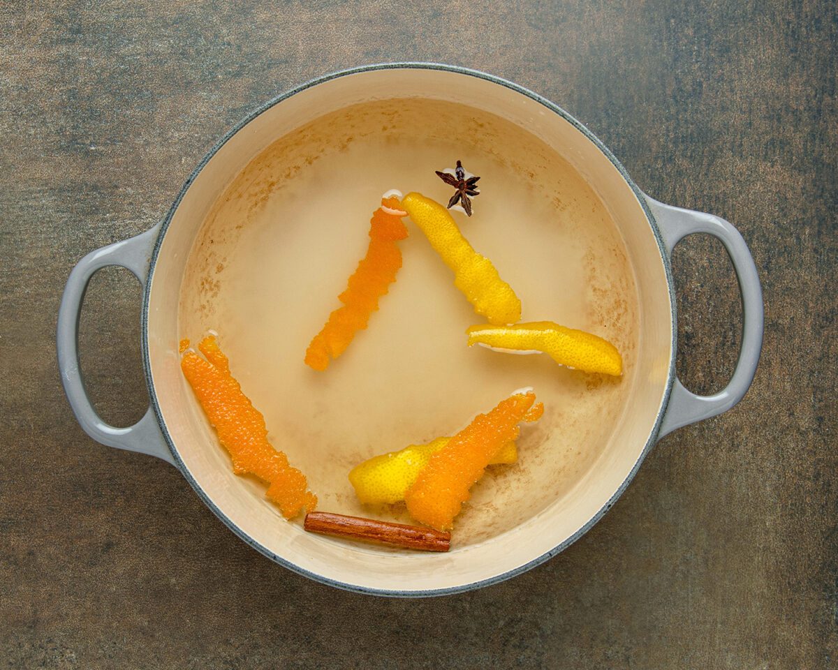 water, wine, sugar, cinnamon stick, lemon peel, orange peel, and star anise in Dutch oven