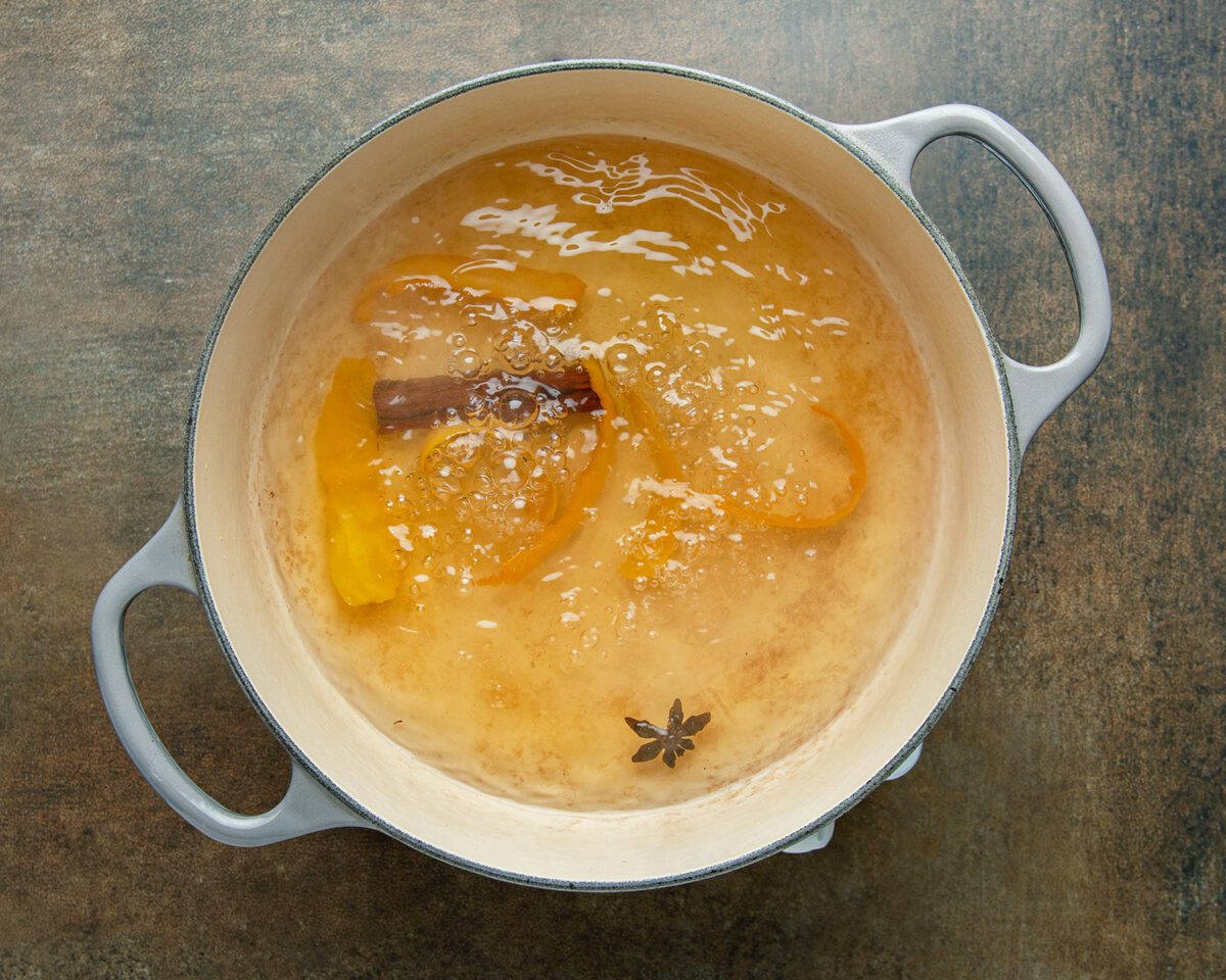 reduced water, wine, sugar, cinnamon stick, lemon peel, orange peel, and star anise in Dutch oven