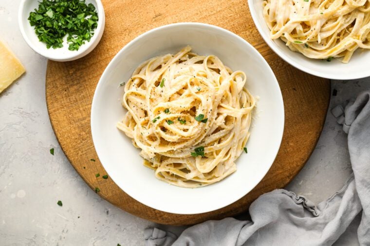 fettuccine alfredo in white bowl with gray napkin to the lower right