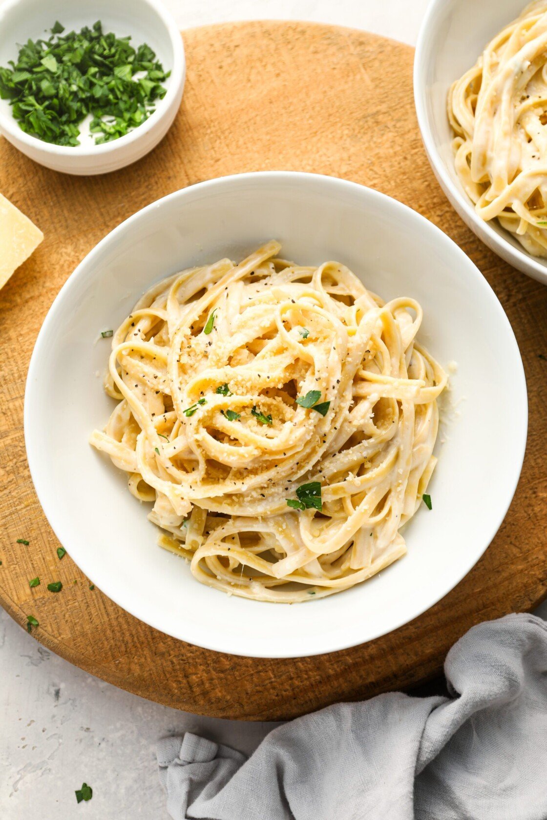 fettuccine alfredo in white bowl with gray napkin to the lower right