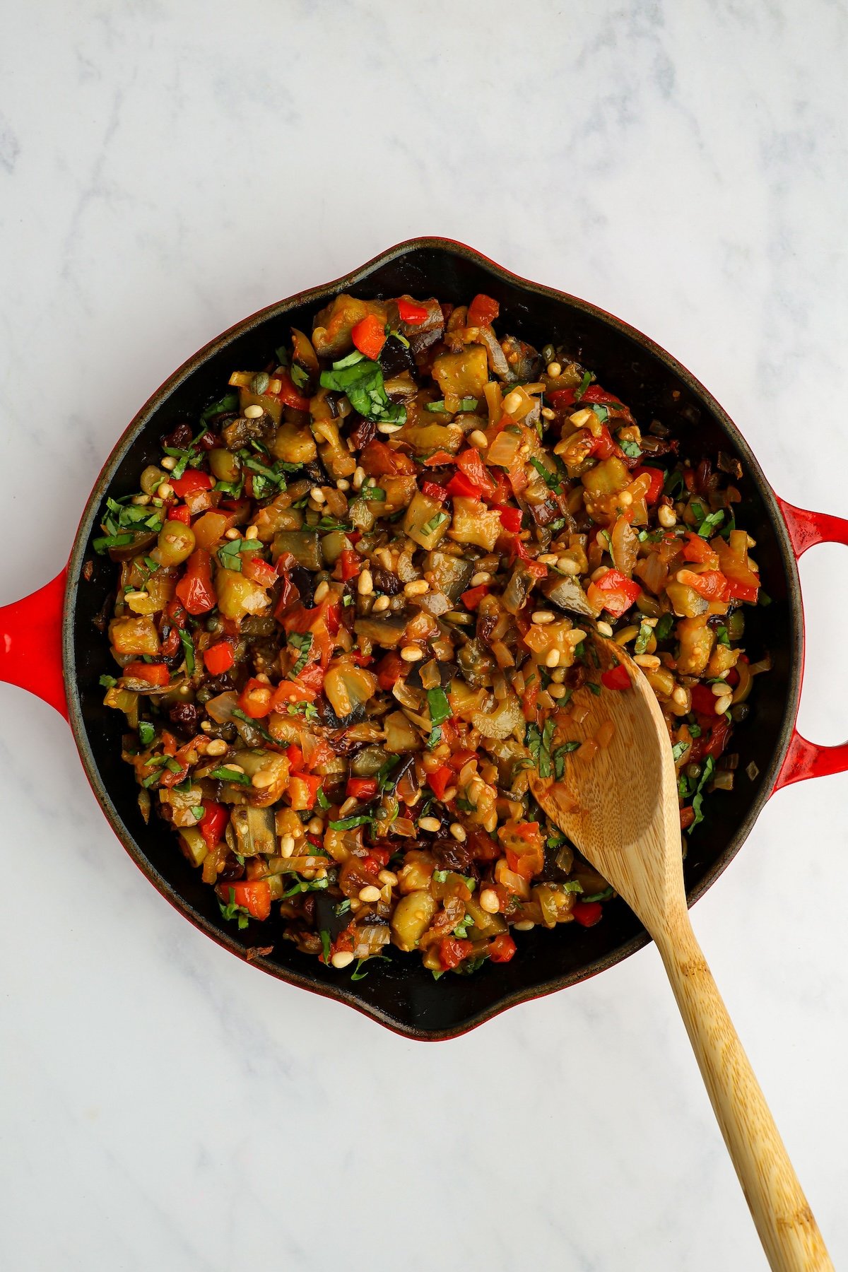 caponata in large skillet with pine nuts and basil mixed in