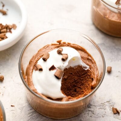 small glass with chocolate mousse topped with whipped cream and chocolate shavings