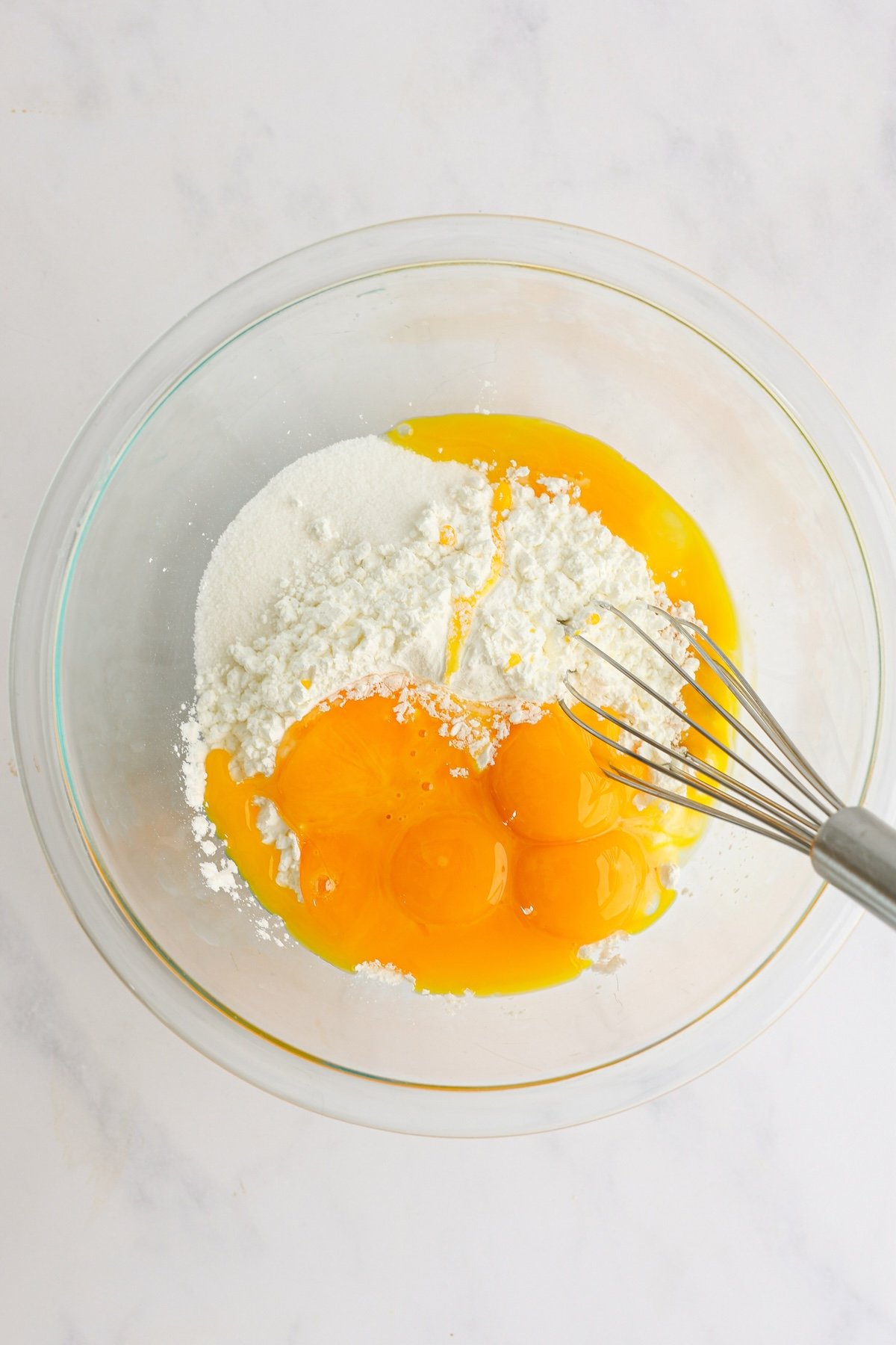 sugar, cornstarch, salt, and egg yolks in a glass bowl with whisk