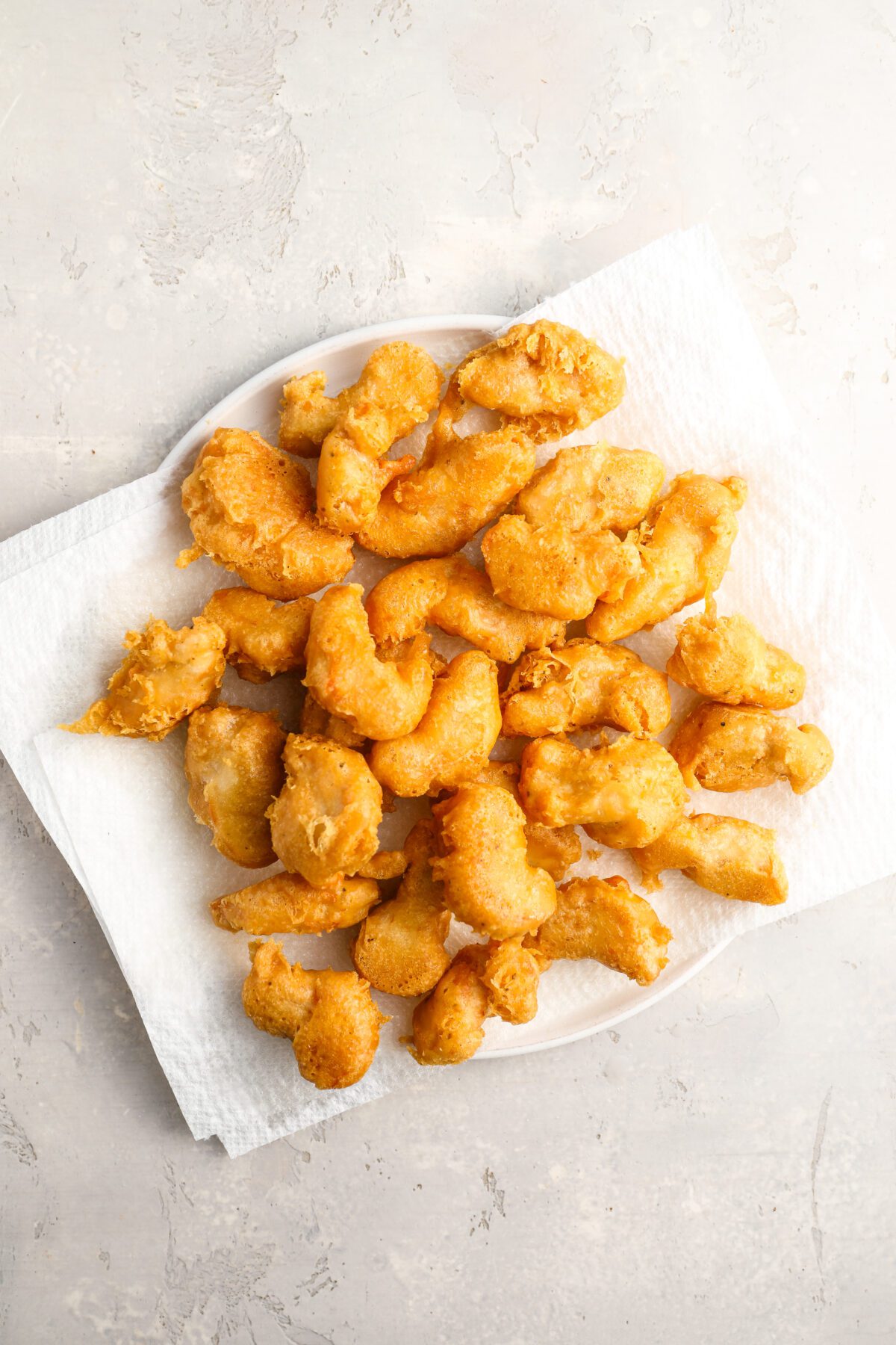 chicken draining on paper towel lined plate
