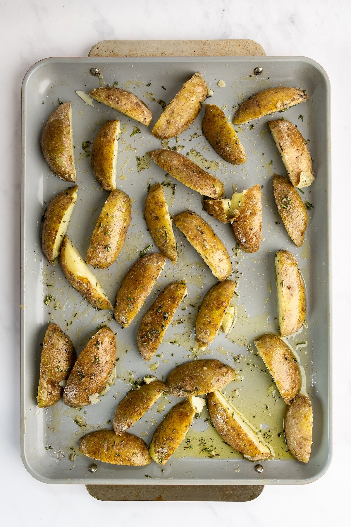 sheet pan with partially baked potato wedges 