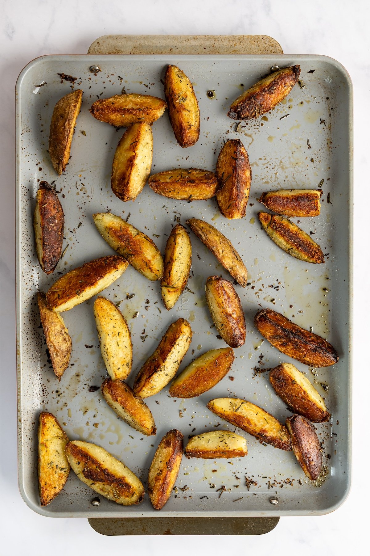 sheet pan with finished crispy baked potato wedges