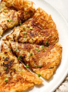 Sliced hash browns on white plate.