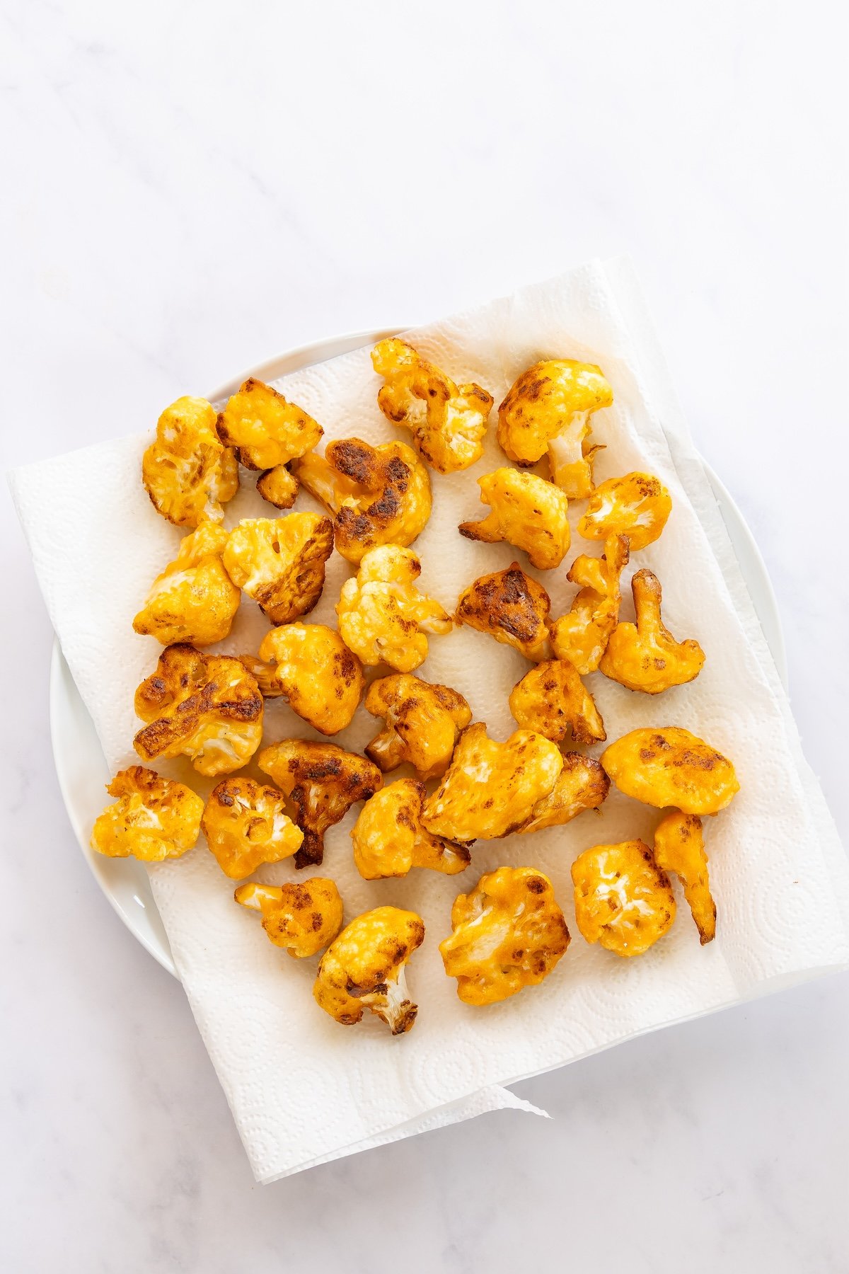 cooked cauliflower on paper-towel lined plate