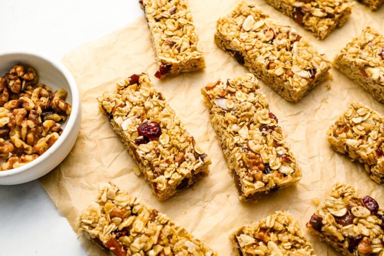 homemade granola bars with bowl of nuts.