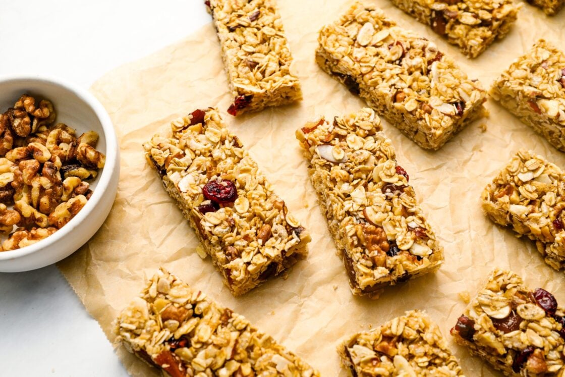 homemade granola bars with bowl of nuts.