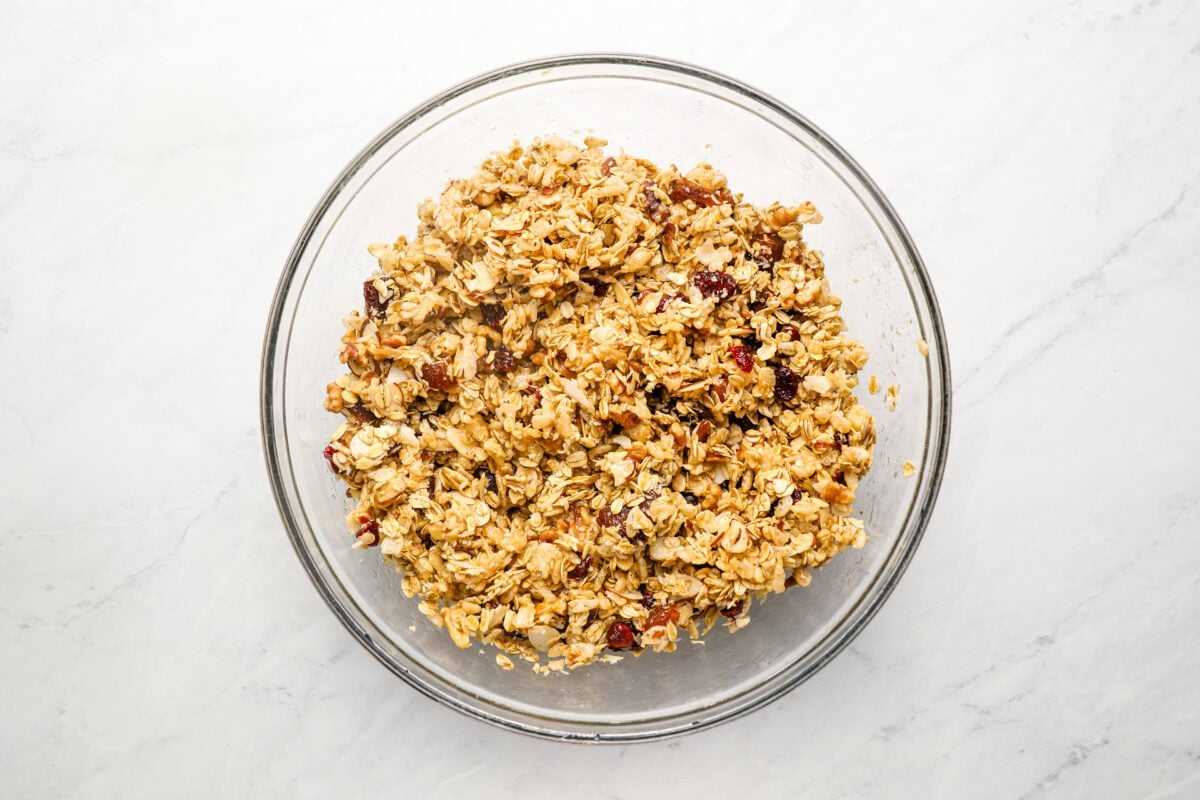large bowl with oat mixture, honey mixture, rice cereal, and dried fruit