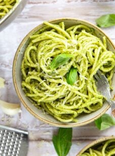 bowl with pesto pasta garnished with fresh basil Parmigiano-Reggiano