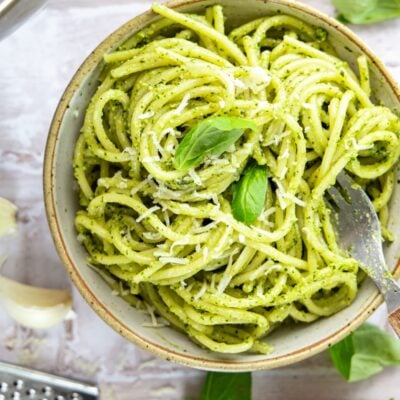 bowl with pesto pasta garnished with fresh basil Parmigiano-Reggiano