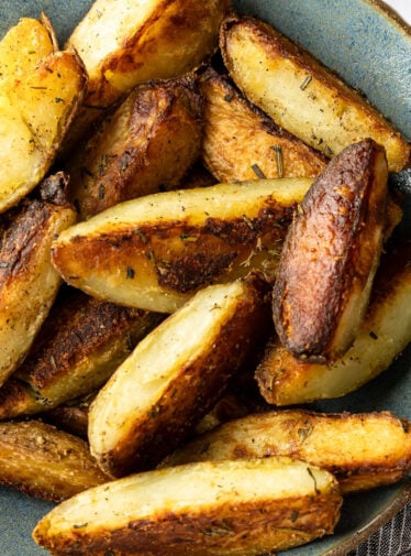 crispy baked potato wedges in gray bowl