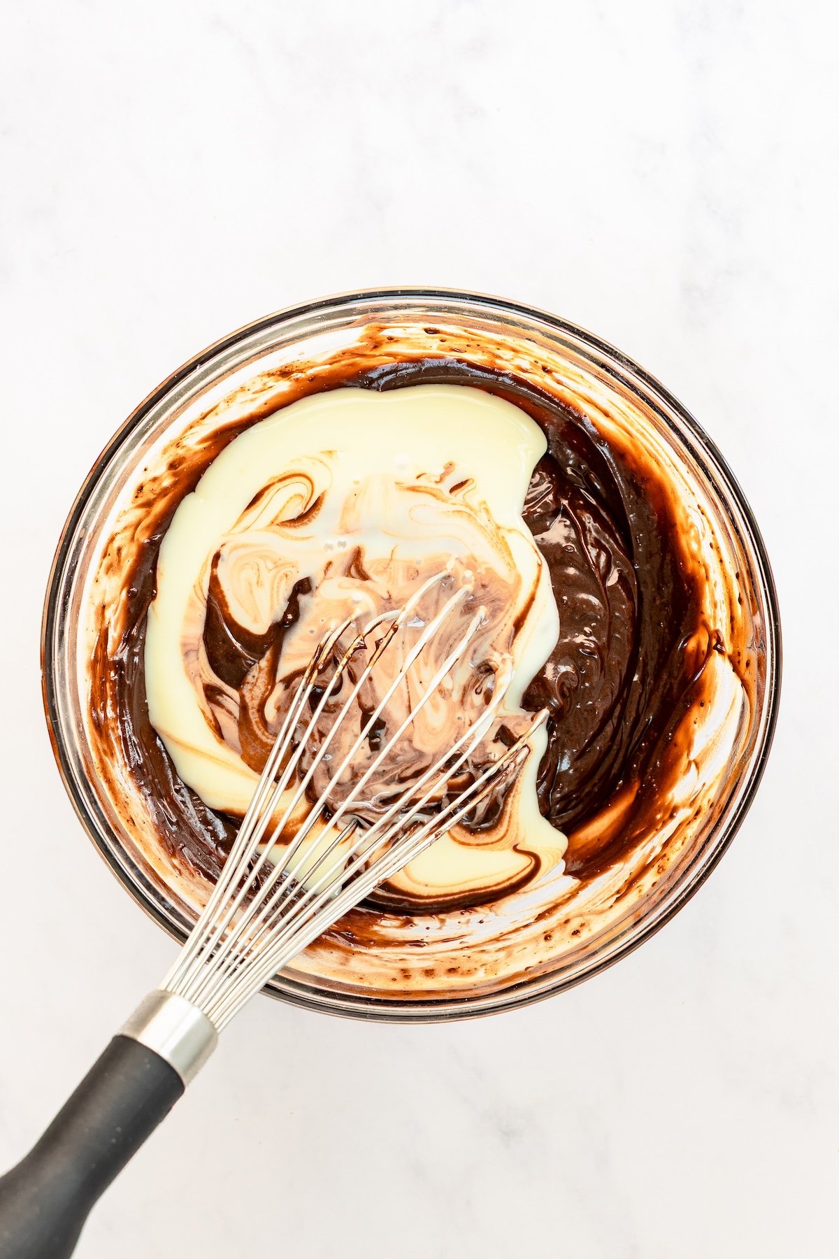 large bowl with sweetened condensed milk added to chocolate pudding