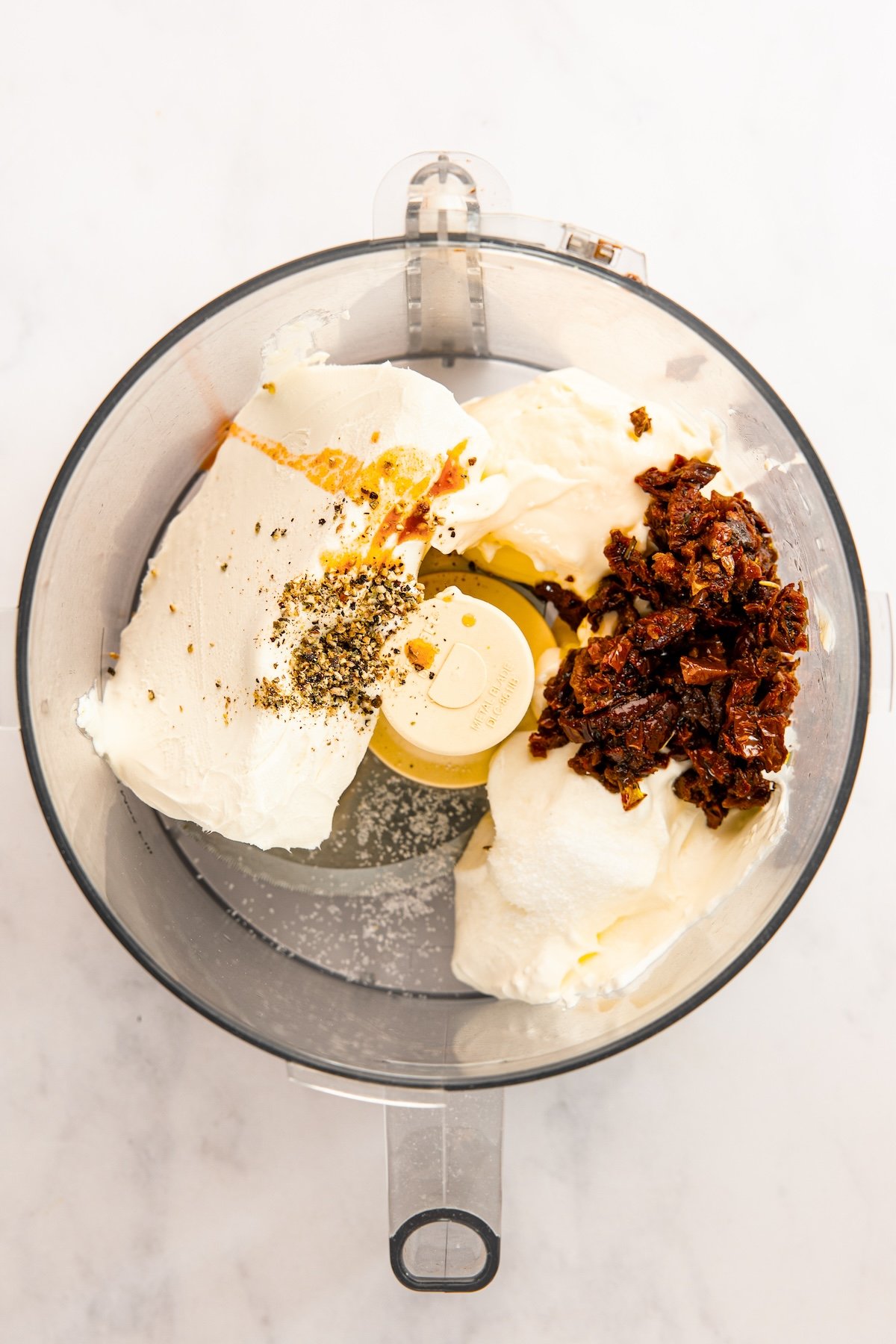 sun-dried tomatoes, cream cheese, sour cream, mayonnaise, Tabasco sauce, salt, and pepper in food processor