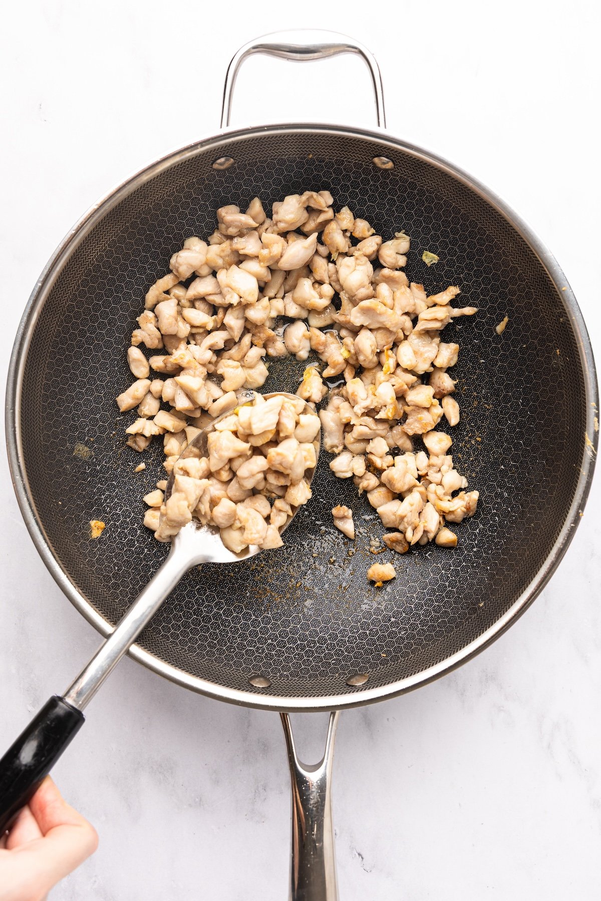 cooked chicken pieces in nonstick skillet
