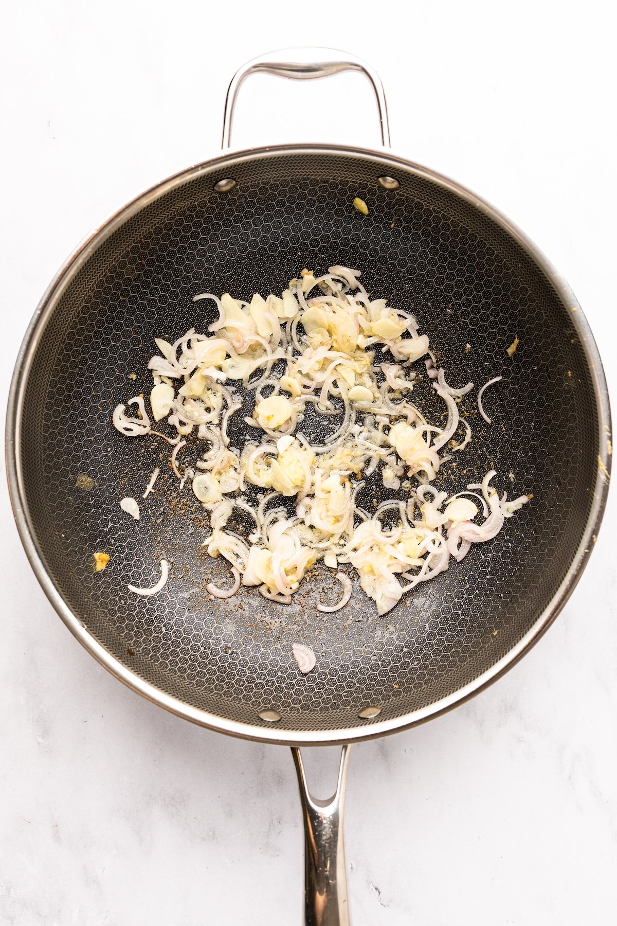 garlic, ginger, and shallots cooking in nonstick skillet