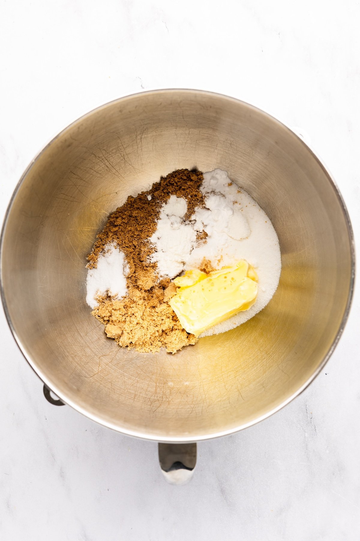 mixing bowl with butter, brown sugars, granulated sugar, vanilla, salt, baking powder, and baking soda