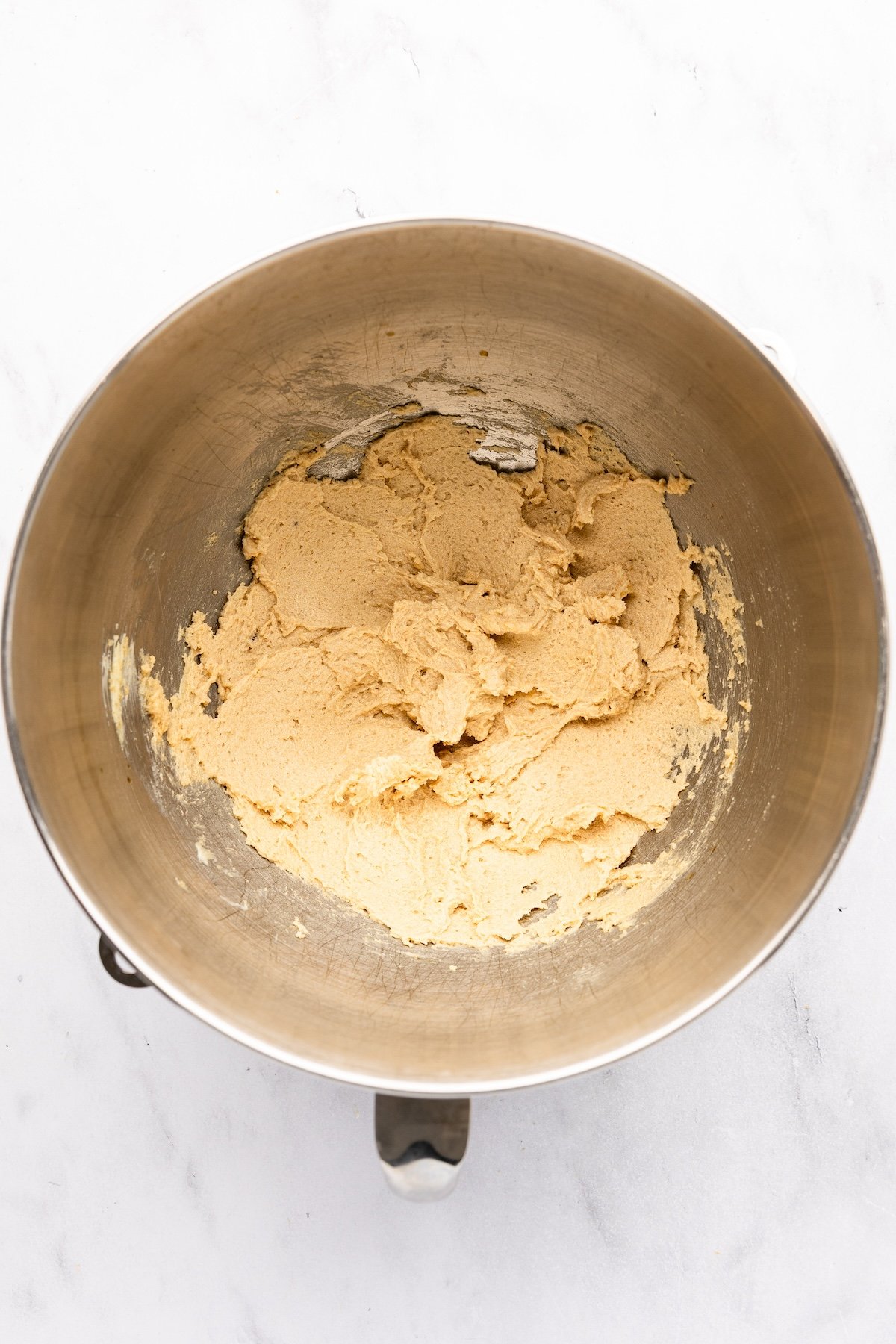 mixing bowl with butter, brown sugars, granulated sugar, vanilla, salt, baking powder, and baking soda combined