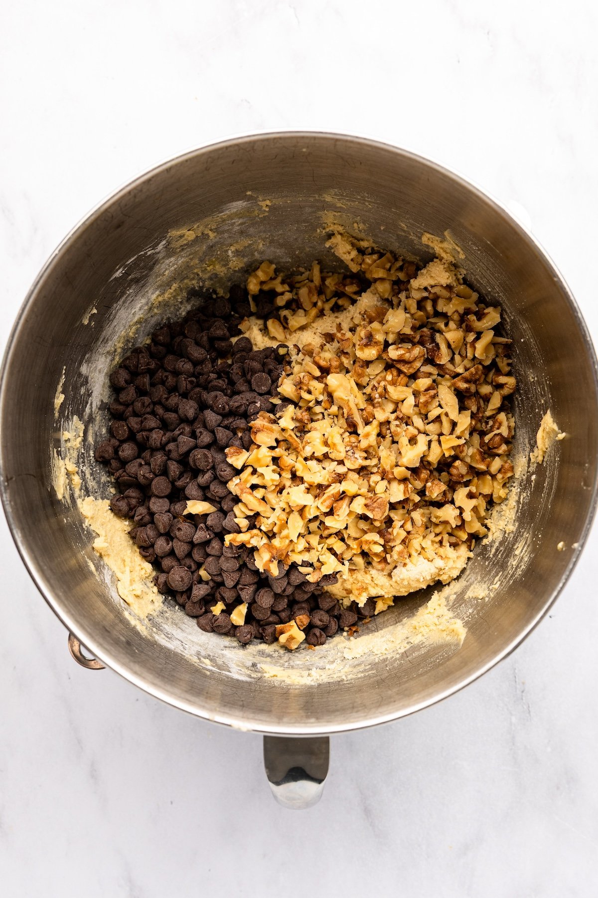 mixing bowl with chocolate chips and pecans added to batter