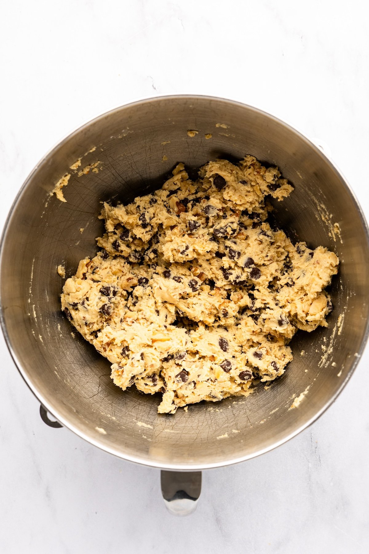 mixing bowl with chocolate chips and pecans mixed into batter