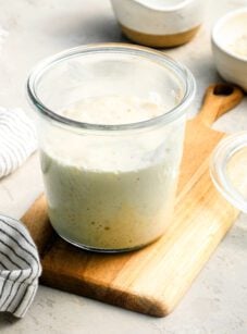 sourdough starter in a jar sitting on a cutting board