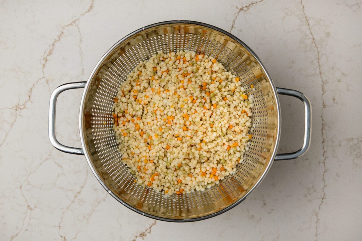cooked israeli couscous in strainer