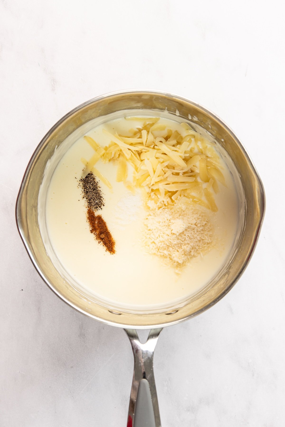 Salt, pepper, nutmeg, gruyere, and pecorino Romano added to butter/flour/milk mixture in medium sauce pan