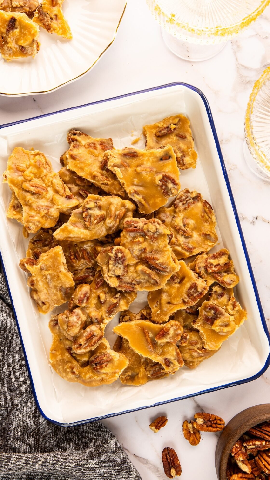 pecan praline pieces stacked on white rectangular serving platter