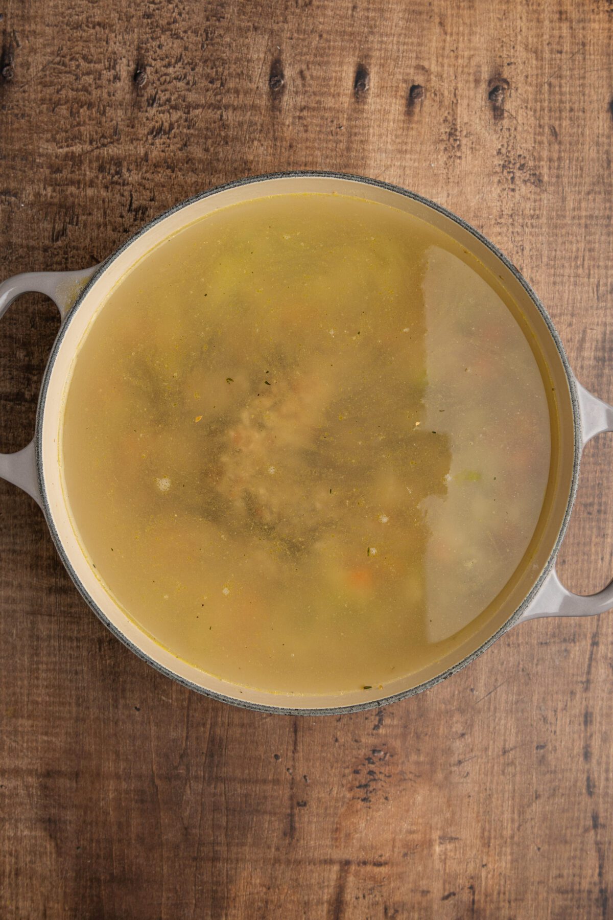 Dutch oven with water, broth and rice added to cooked vegetable mixture