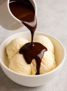 pouring chocolate sauce over ice cream