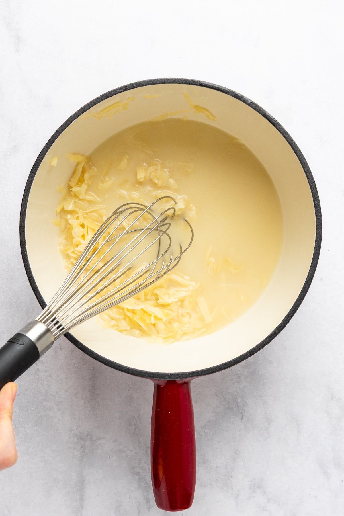 whisking Gruyère/Emmentaler/cornstarch mixture into wine and kirsch in fondue pot