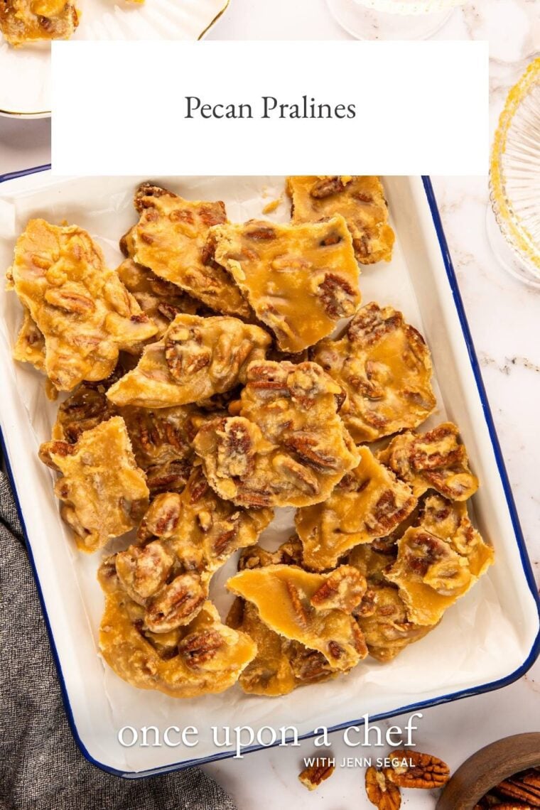 pecan praline pieces stacked on white rectangular serving platter