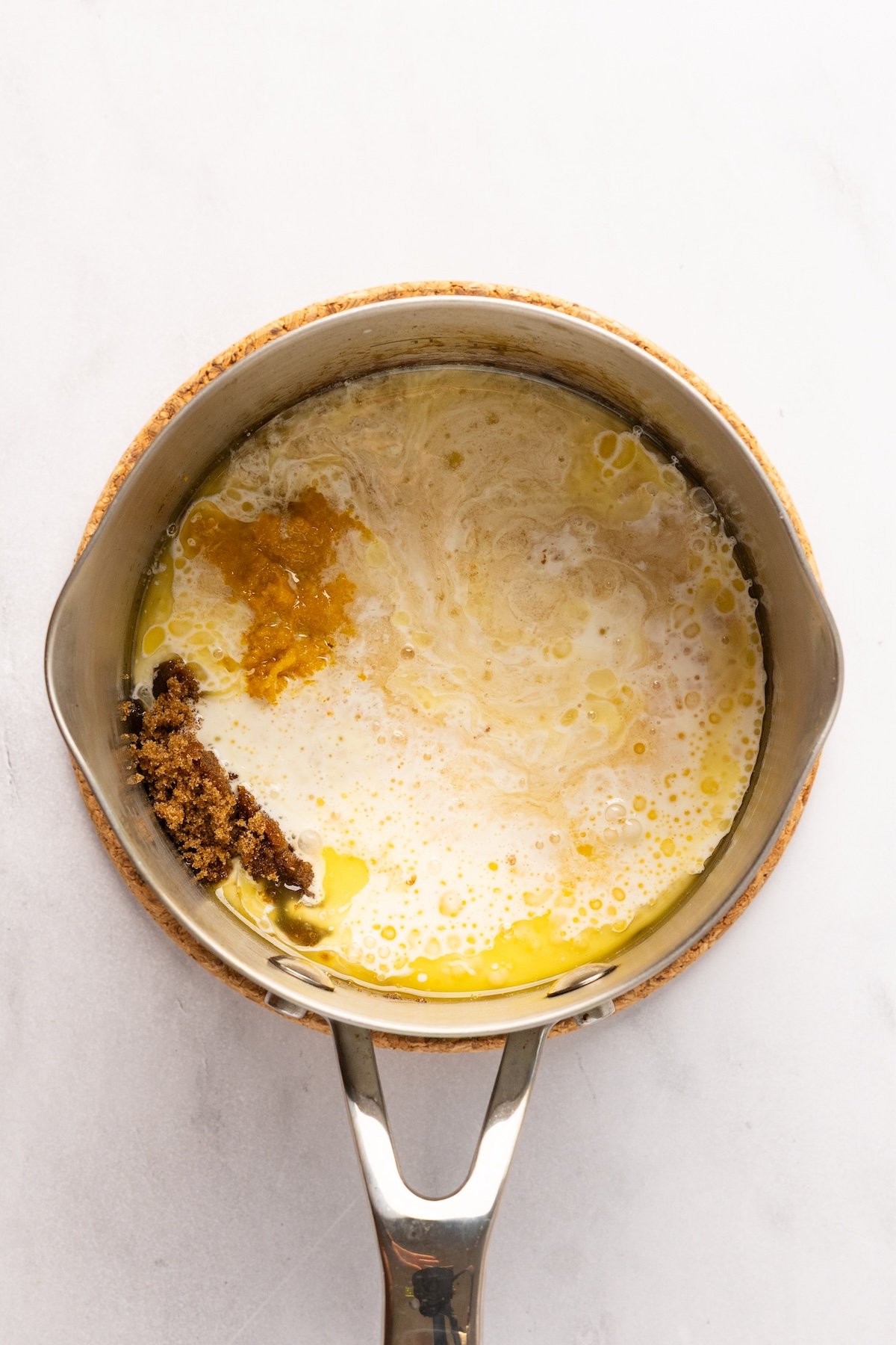 small saucepan with melted butter, brown sugar, cream, vanilla, salt, and whiskey