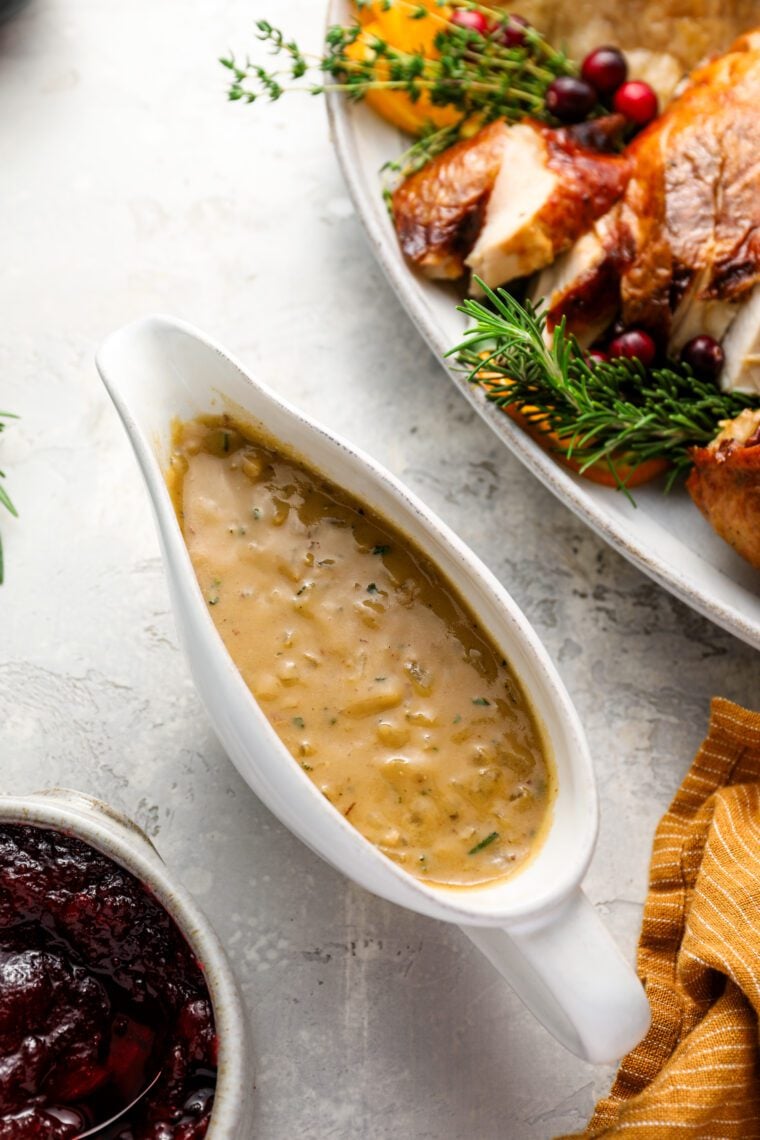 turkey gravy with platter or carved turkey and cranberry sauce