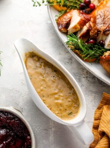 turkey gravy with platter or carved turkey and cranberry sauce