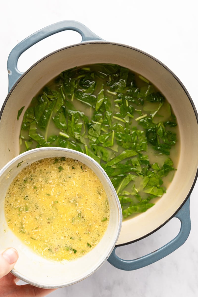 adding egg mixture to broth and spinach