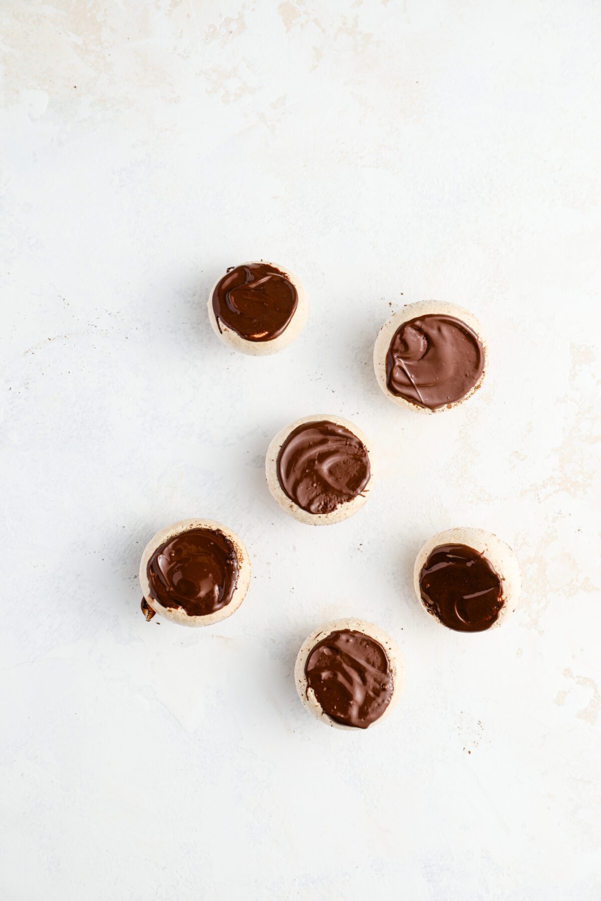 Mushroom caps with layer of melted chocolate on underside